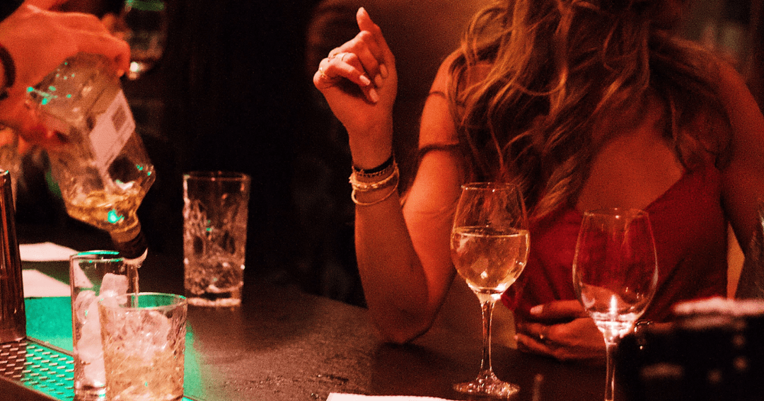 Lady Sitting At Bar With A Drink