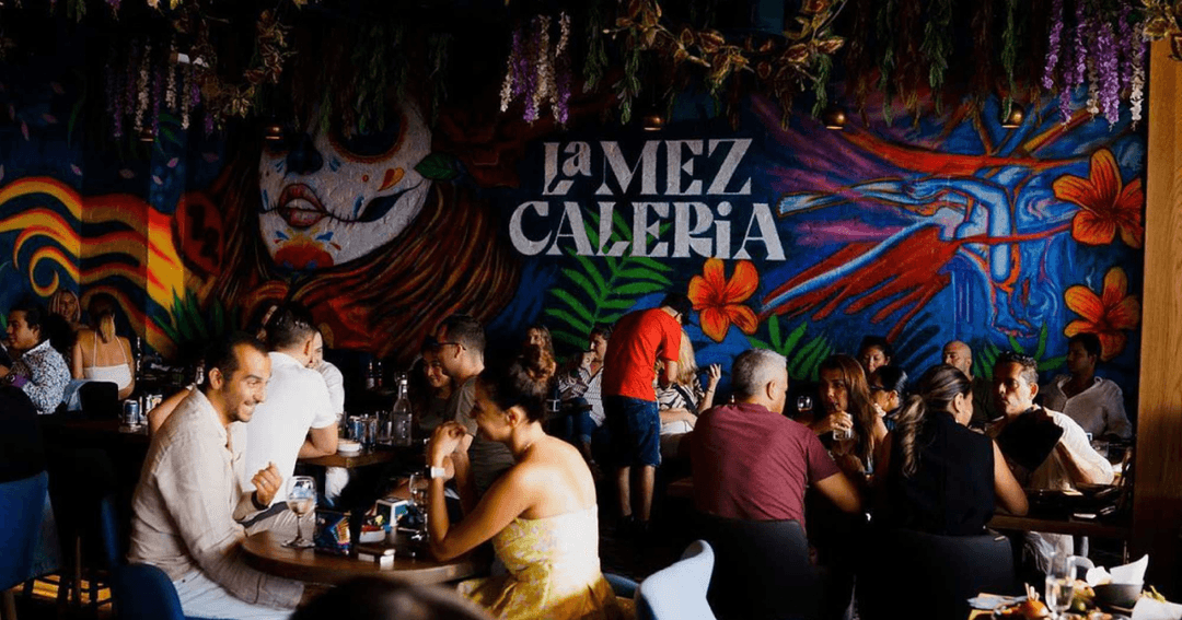 Guests enjoying food and drinks at La Mezcaleria