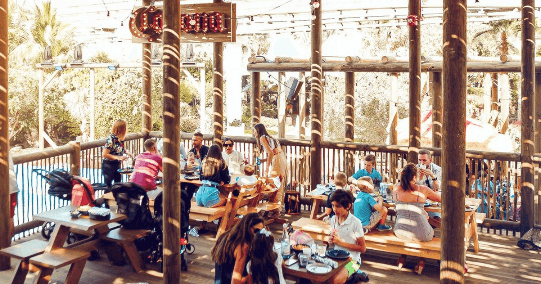 Families eating and drinking at Warehouse's outside sitting area.