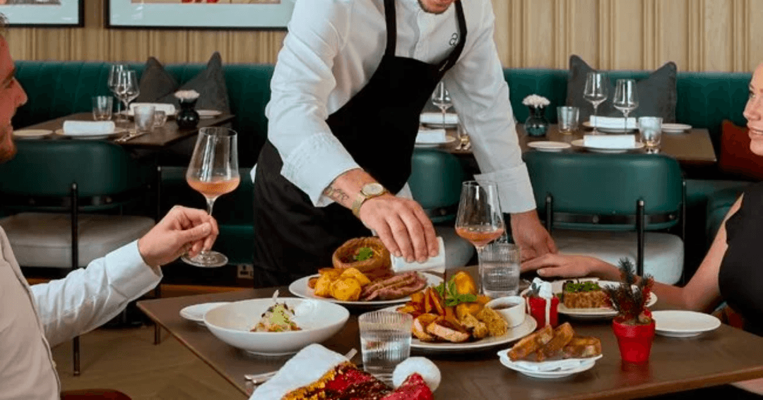 Waiter preparing a couple's table