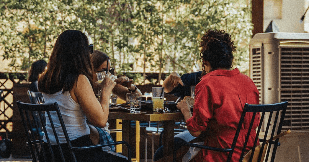 Group of friends having a meal at Folly's terrace