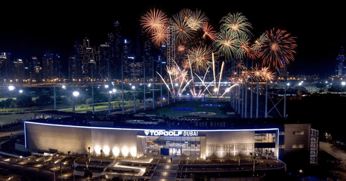 Overview over Topgolf venue with fireworks in the background.