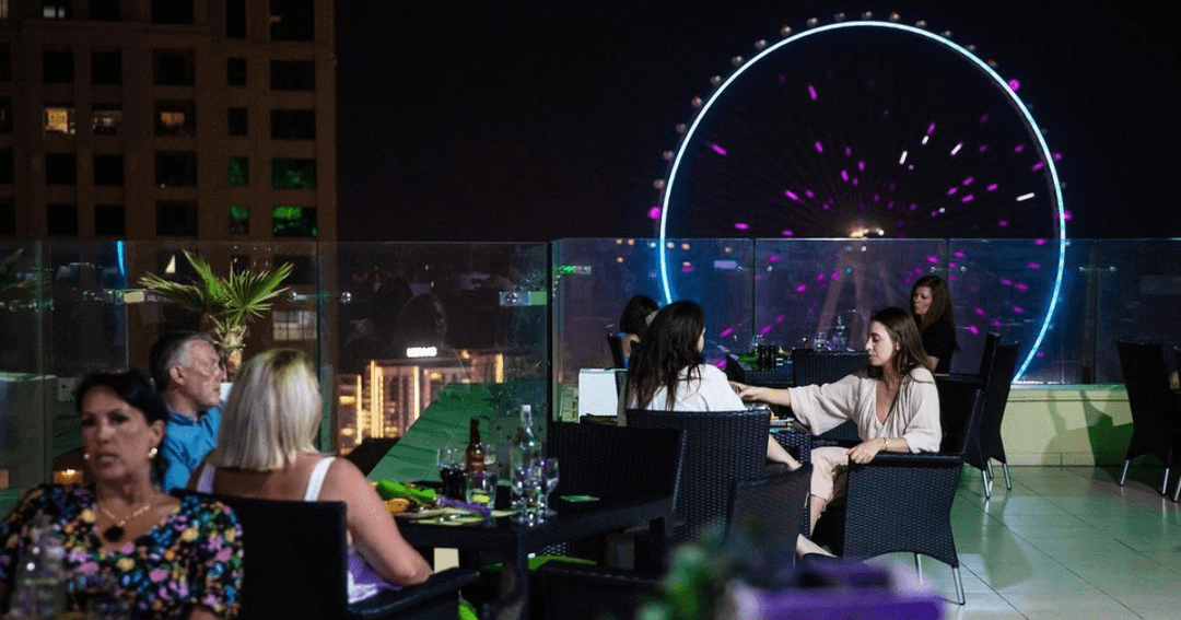 Guests dining at Fogueira with a view of the Dubai wheel