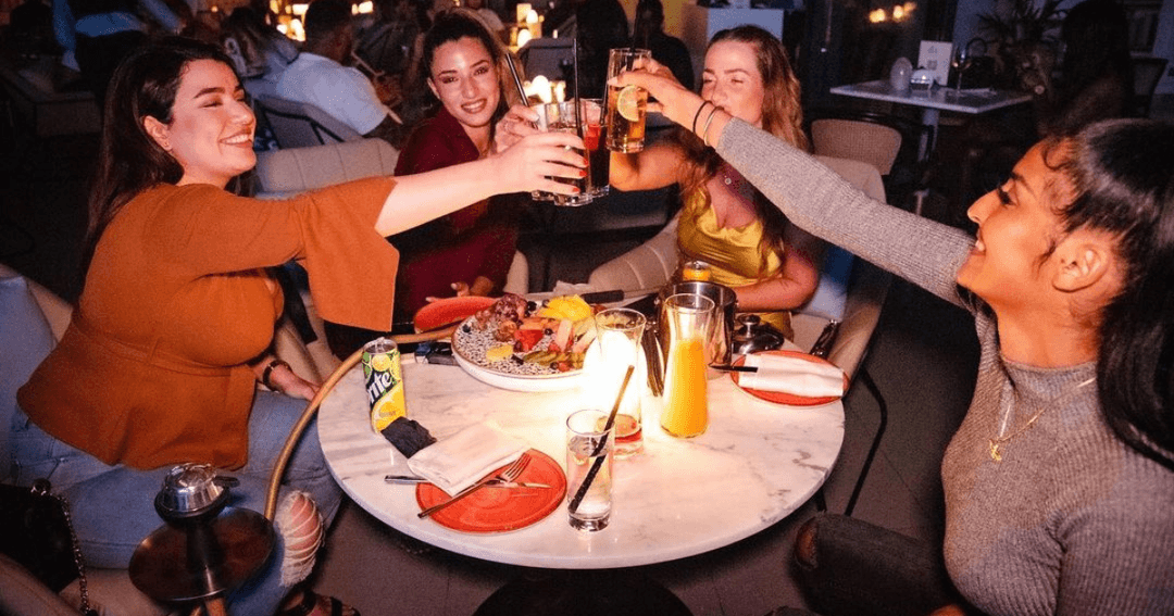 Four friends toasting their drinks at Somiya Lounge