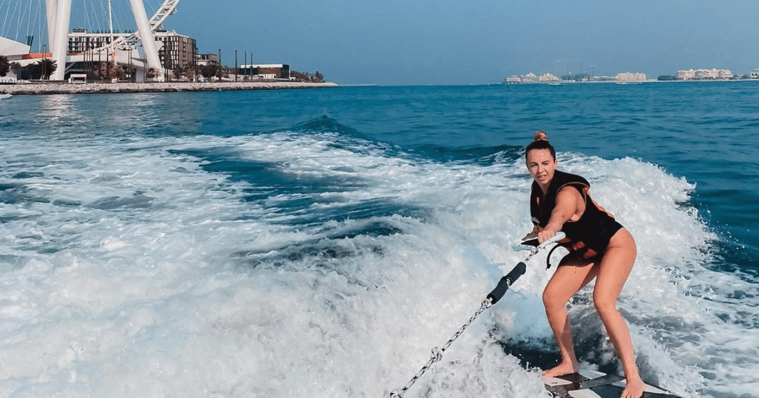 Woman wakeboarding with Ain Dubai in the background