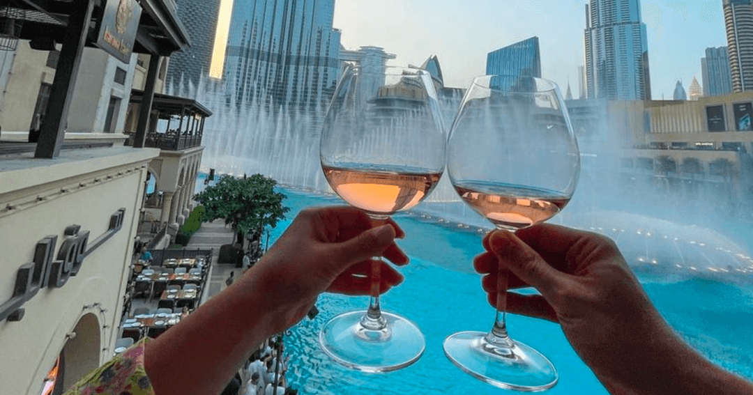 Two wine glasses with a backdrop of Dubai Fountains 