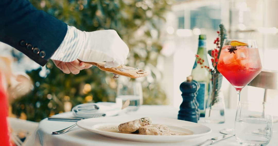 Waiter grating truffle on food