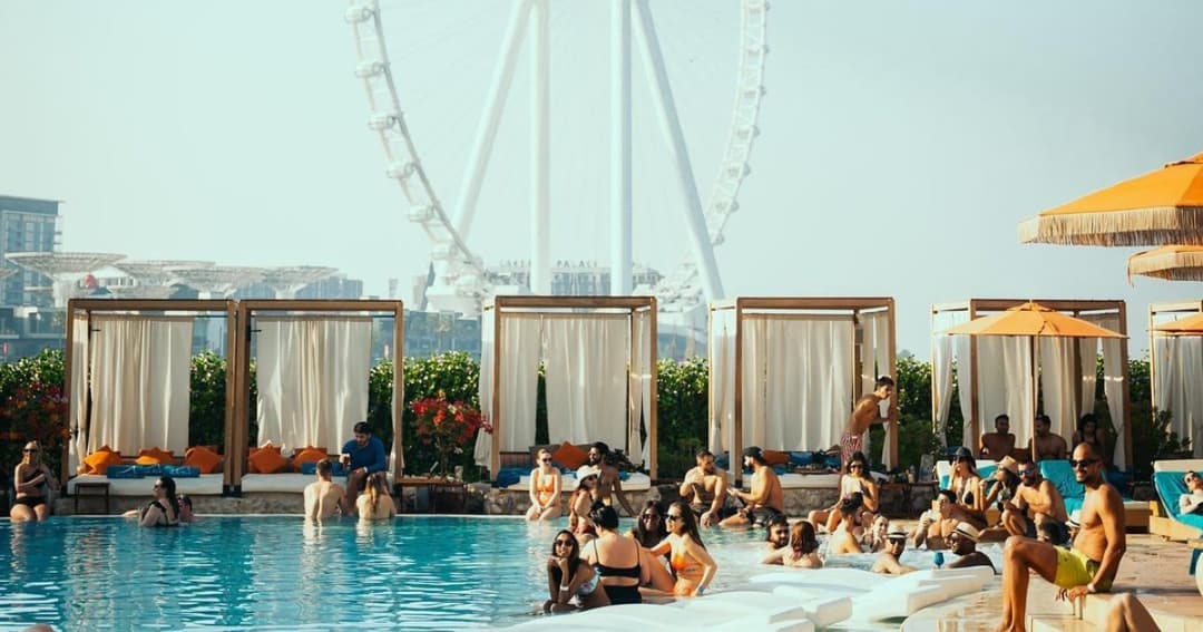 People in the pool with Al Ain wheel in the background