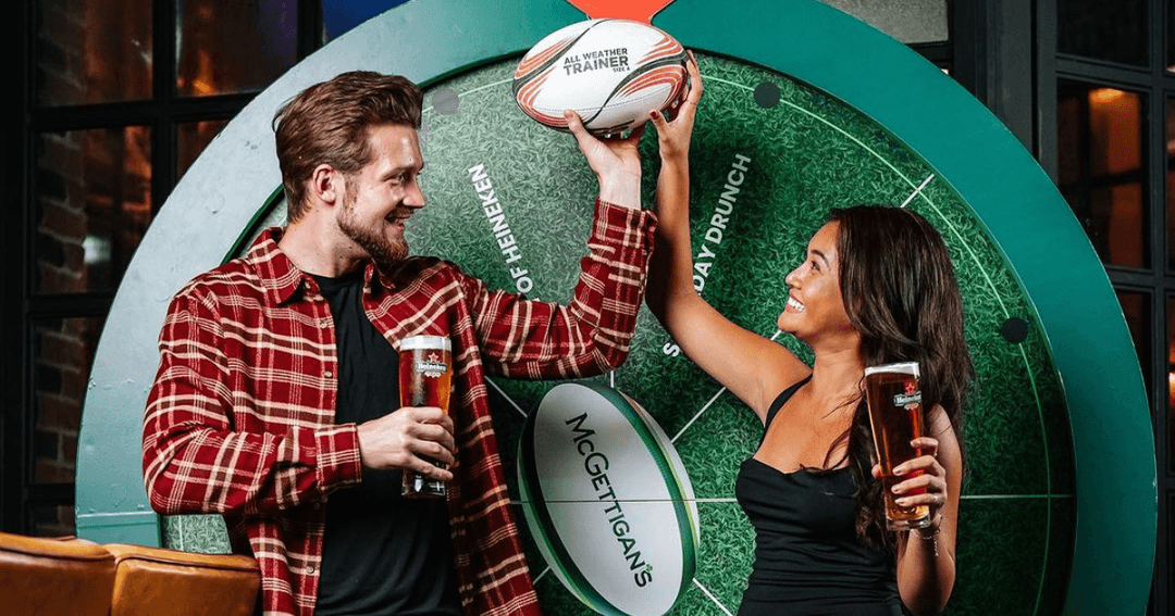 Two people holding a rugby ball