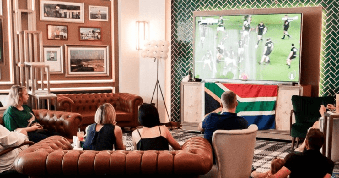 Guest watching a rugby match from a sofa