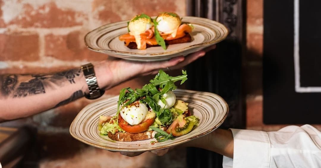 Waiters holding two plates with food