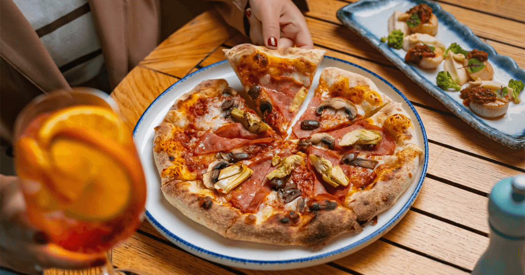 Guest enjoying pizza and a drink