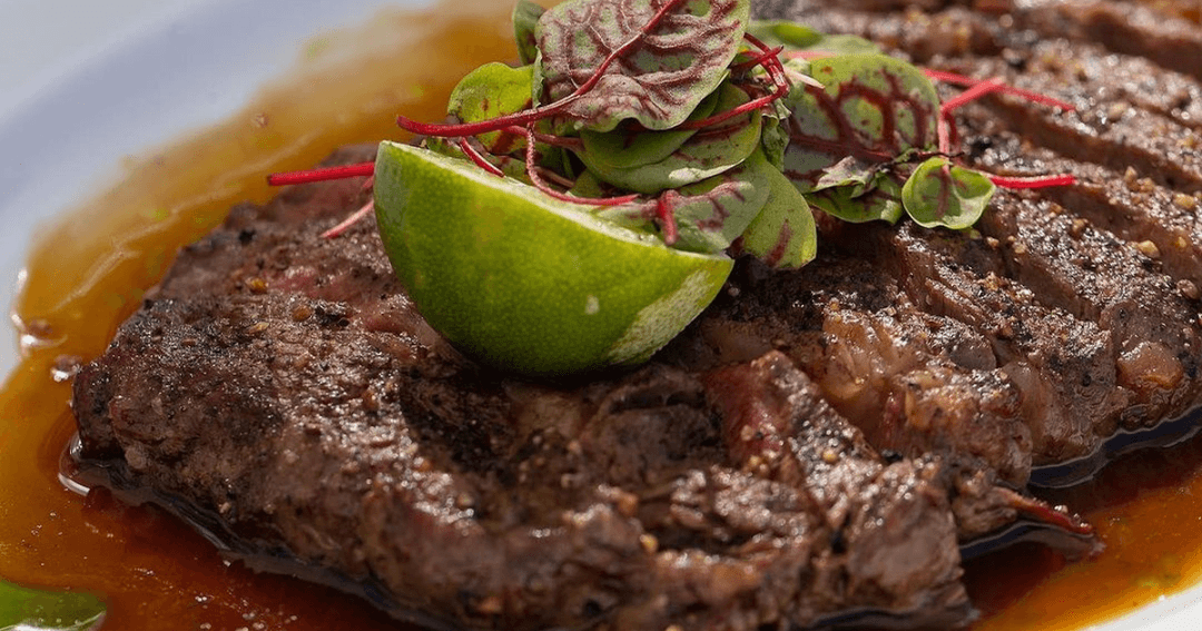 Steak served with lime and herbs on top