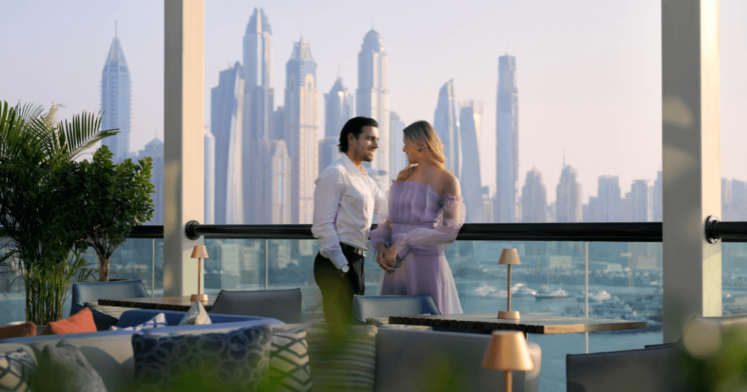 A couple standing at a rooftop bar