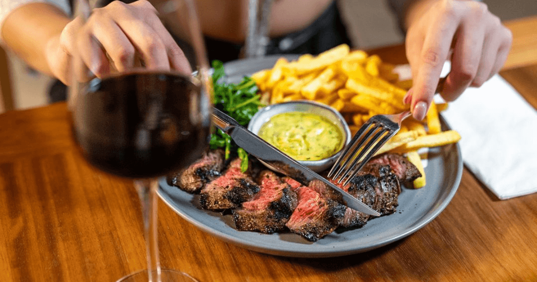 Steak, frites and wine served on the table