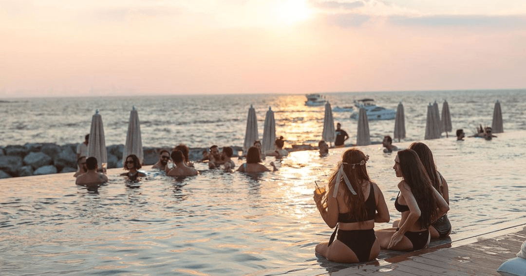 People in the pool with a sunset