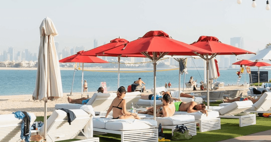 Guest laying on sunbeds by the beach