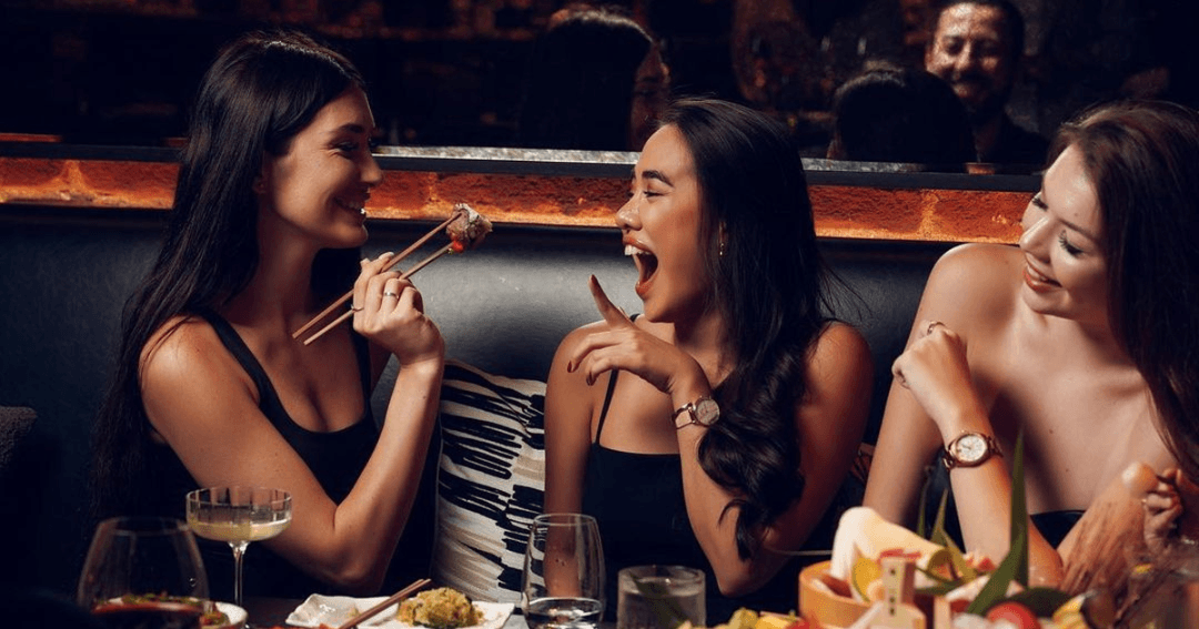 Three girls eating and drinking at OKKU