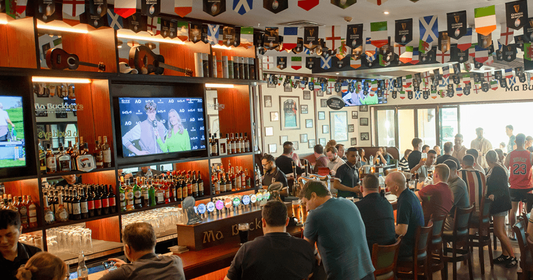 Guests sat by the bar watching sports on live TV