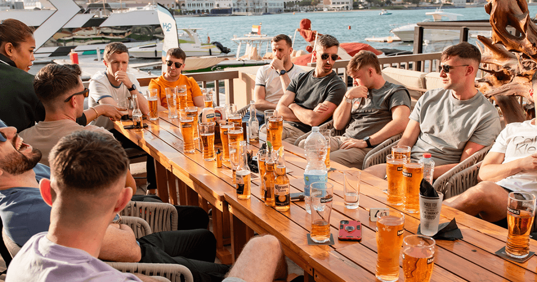 Group of men sat at a table drinking beer