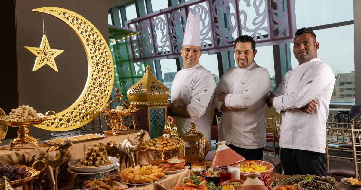 Three Chef's standing next to an Iftar Buffet table