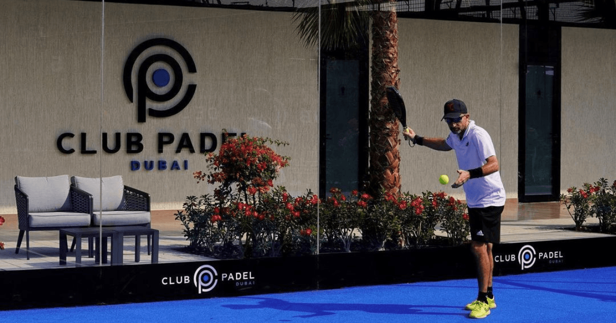 man holding padel racket at club padel court