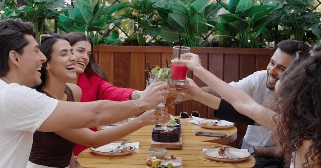 friends sitting at a table, eating and drinking 