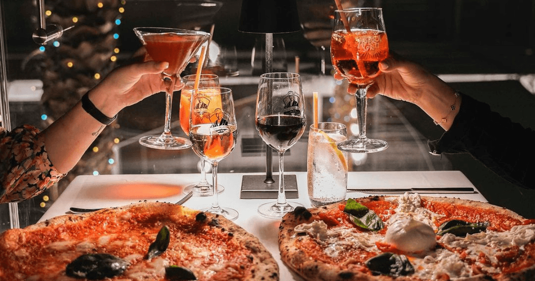 two people dining at pizza place and drinks