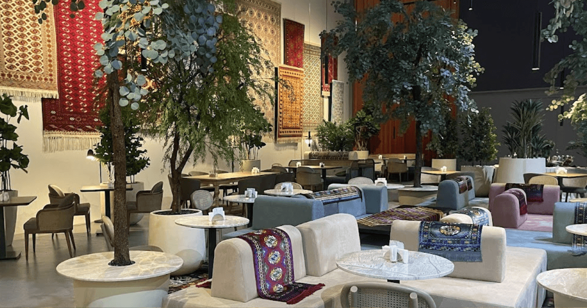 The cozy interior of Talhan Expo City, featuring a blend of modern and traditional decor with lush greenery and patterned wall hangings.