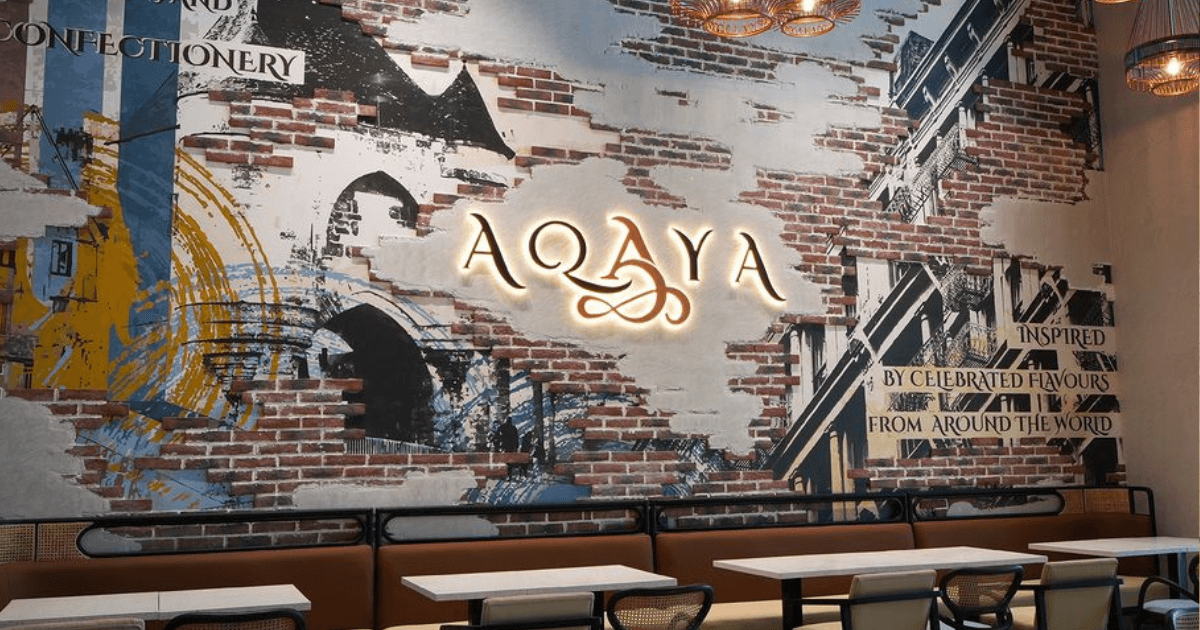 Chic interior of Aqaya at Dubai Creek Harbour, showcasing unique wall art and a modern dining ambiance.