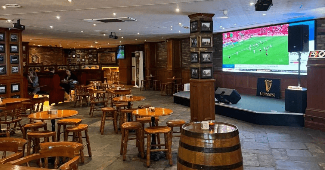 Spacious seating area and large screen for sports viewing at Fibber Magee's in Dubai.