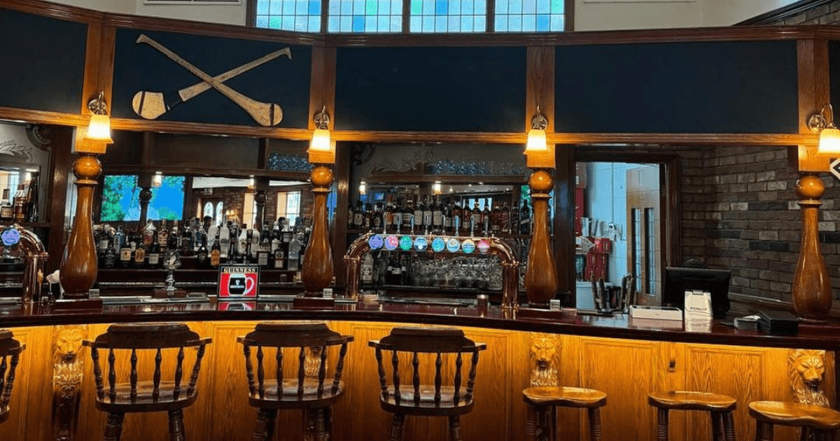 Traditional wooden bar with taps and stools at Fibber Magee's in Dubai.