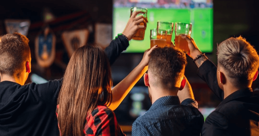 Friends raising their glasses at Harvester's Dubai while enjoying the 2024 Euros matches.