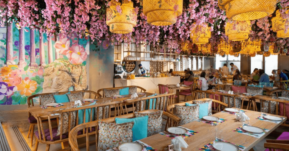 Charming interior of Grand Beirut restaurant at Expo City Dubai, adorned with vibrant floral decor and cozy seating