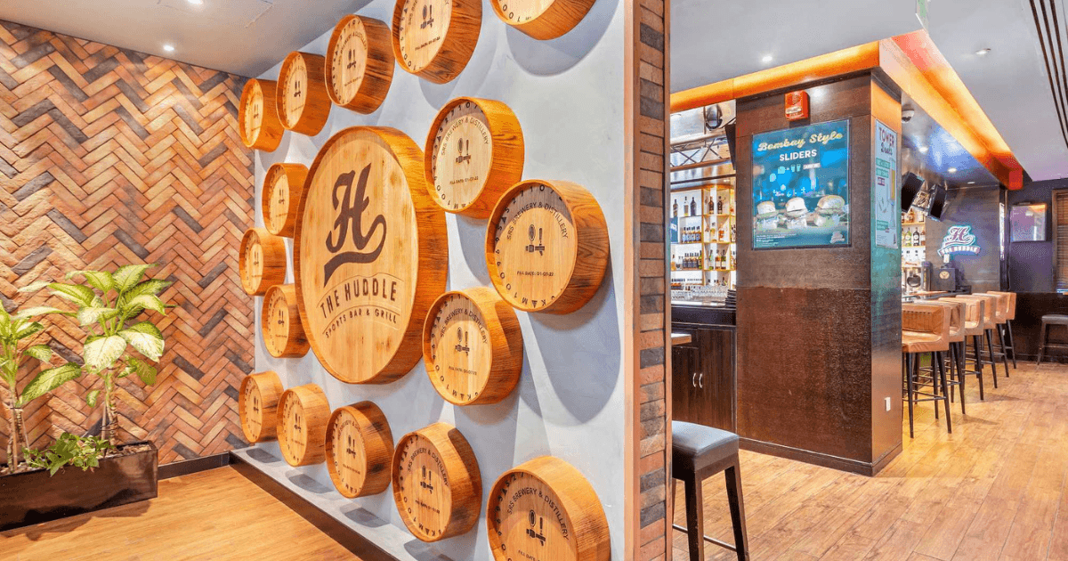 Decorative wall featuring barrel designs at The Huddle Sports Bar & Grill in Dubai.