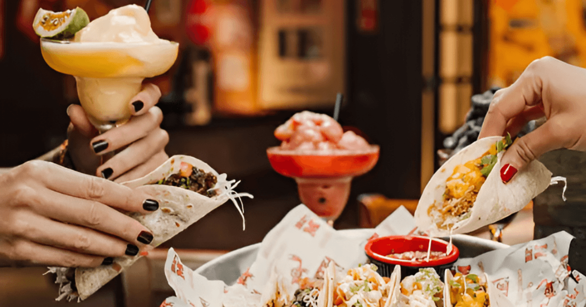 Friends holding and eating tacos in Claw BBQ, Palm Jumeirah, Dubai