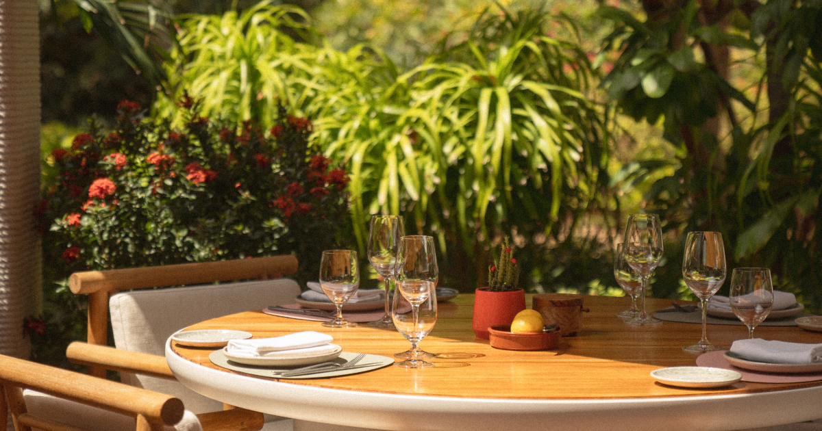 Elegant table setting surrounded by lush greenery at Alizée, Banyan Tree Hotel, Bluewaters, Dubai