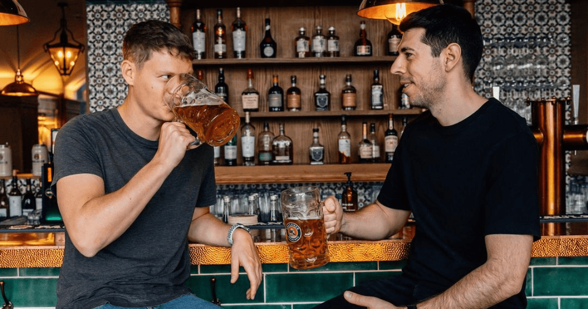 two men drinking beer at the bar